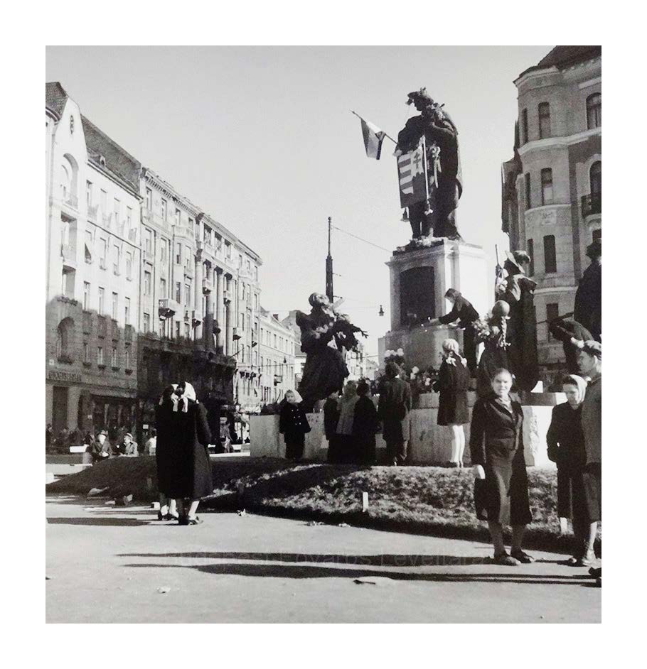 6. A Szent Imre-szobor elé virágot tesznek, a szobor kezében nemzeti színű zászló lobog, pajzsára pedig az ún. Kossuth-címert erősítették rá (Budapest, XI. kerület, Móricz Zsigmond körtér, 1956. október 25. körül)<br><i>(BFL XV.19.g.1.0630)</i>